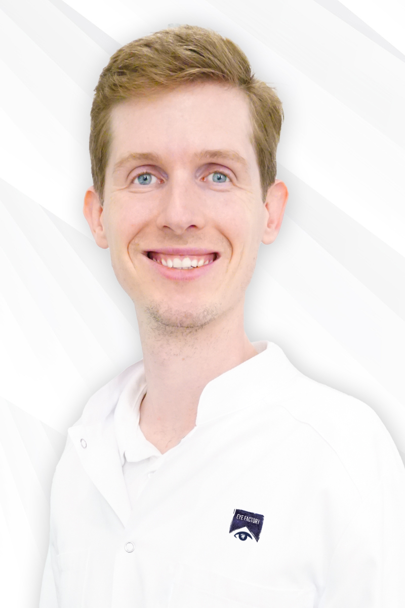 Ein Arzt mit kurzen blonden Haaren, blauen Augen und weißem Kittel