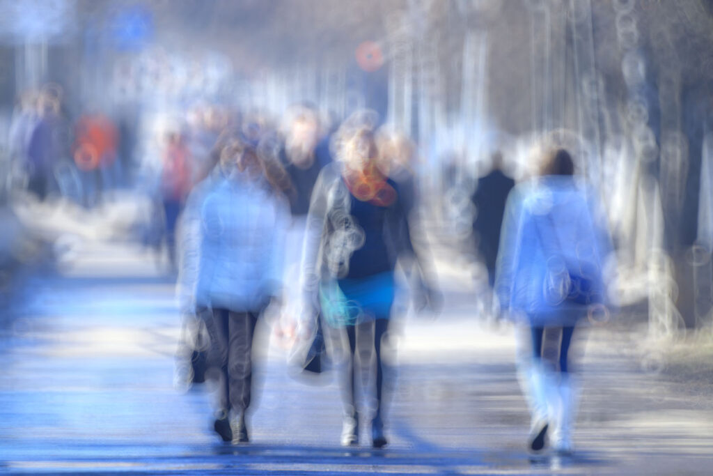 Verschwommenes Bild von drei Menschen auf einer Straße spazierend