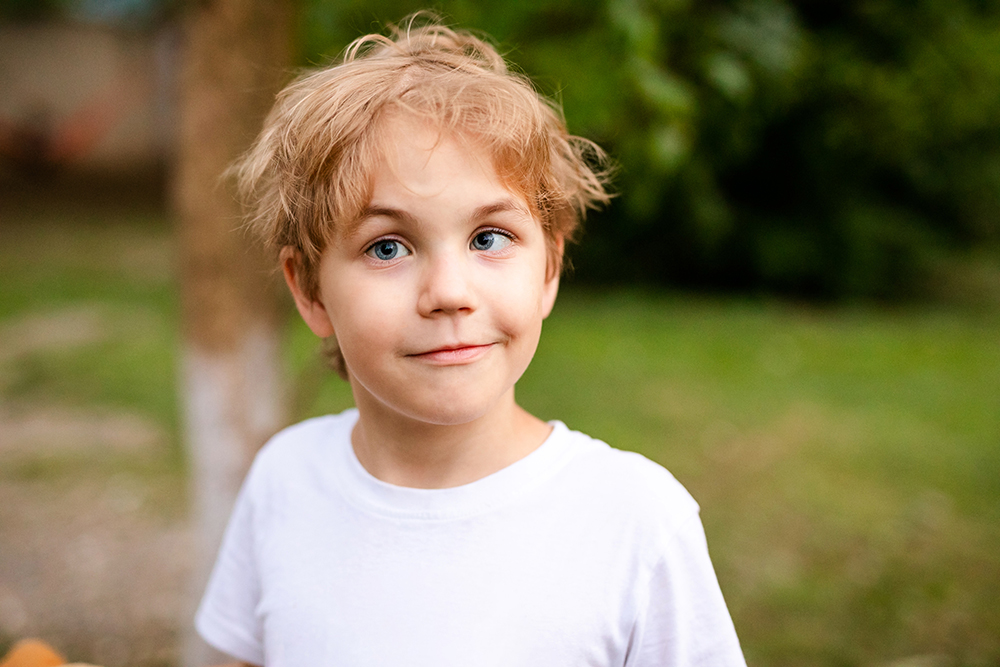Junge mit T-Shirt, dessen Auge schielen