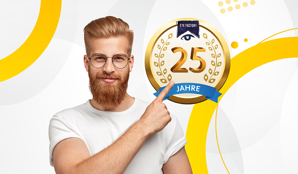 Junger Mann mit Brille und T-Shirt zeigt auf das 25 Jahre Eye Factory Logo