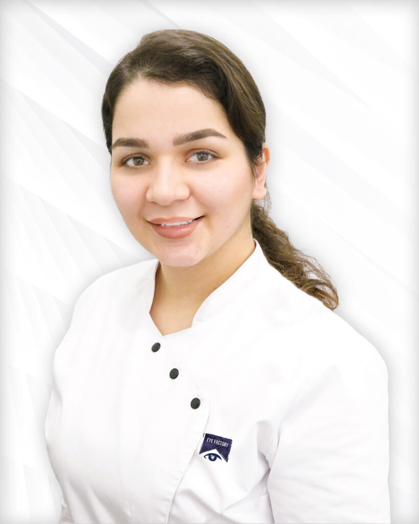 Augenarztmitarbeiterin mit langen Haaren und Arbeitskleidung