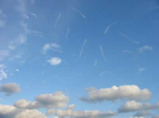 Eine schwache Glaskörpertrübung in Form von transparenten fliegenden Mücken vor blauem Himmelshintergrund
